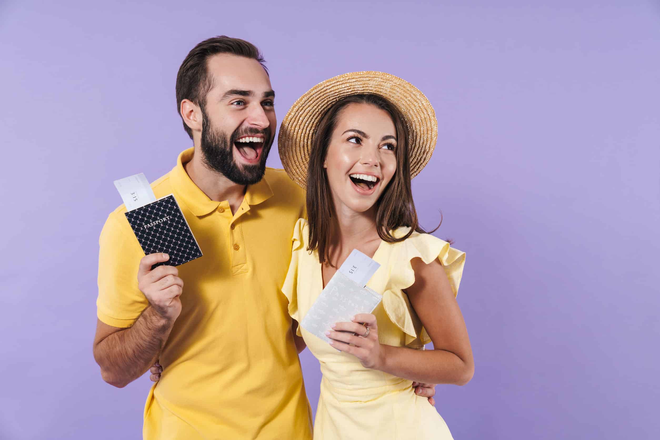 Happy excited beautiful young couple showing passport with flight tickets